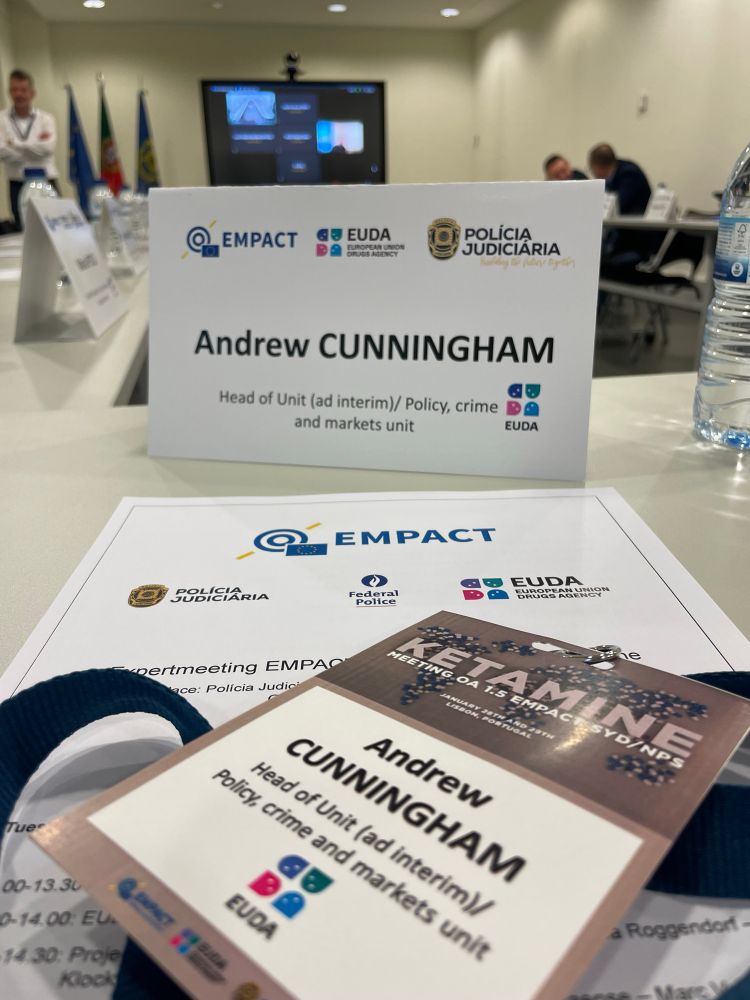 Name badge and lanyard of showing logos of EMPACT (the European Multidisciplinary Platform Against Criminal Threats), the Portuguese Polícia Judiciária, The European Union Drugs Agency and the Belgian Federal Police. 