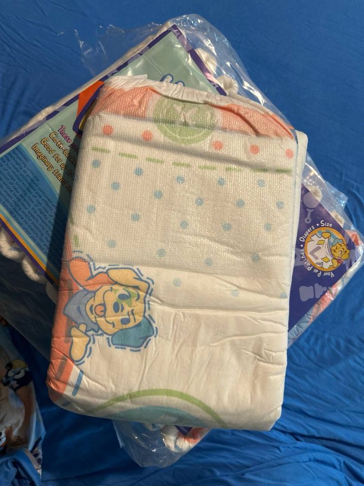 Little troubles' new diaper laying on a pack of them