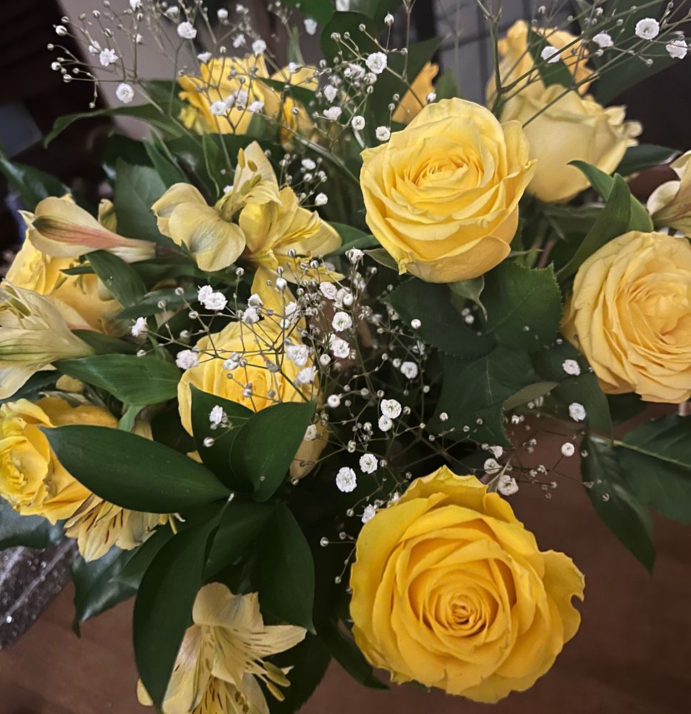 A bouquet of yellow roses and greenery.