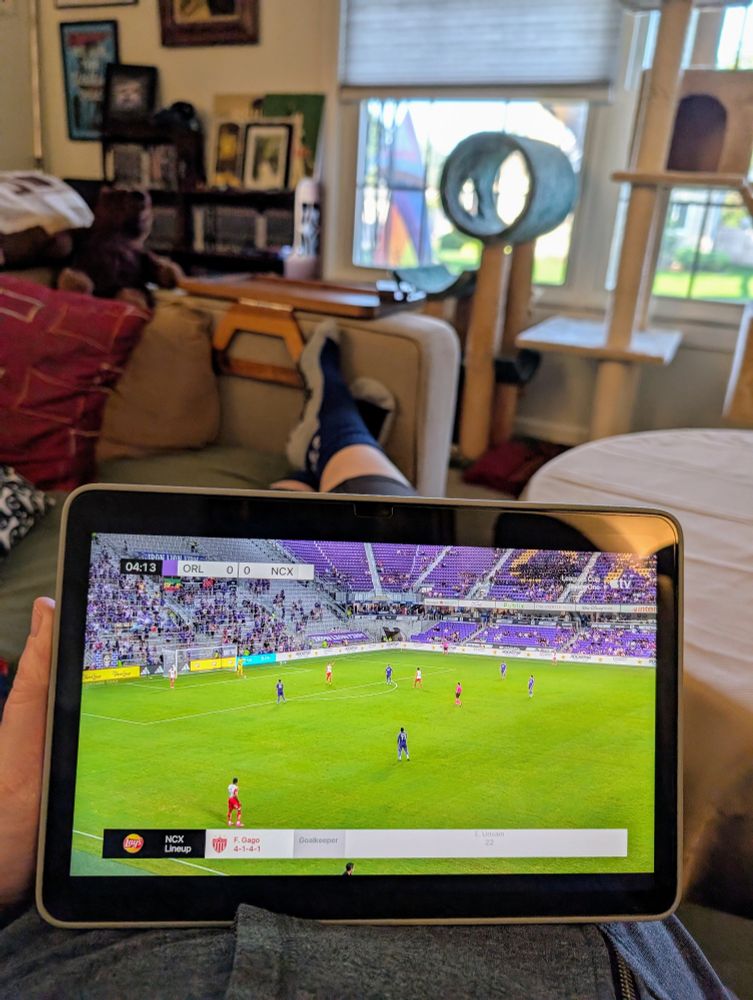 Mona lounges on the couch watching a soccer match...