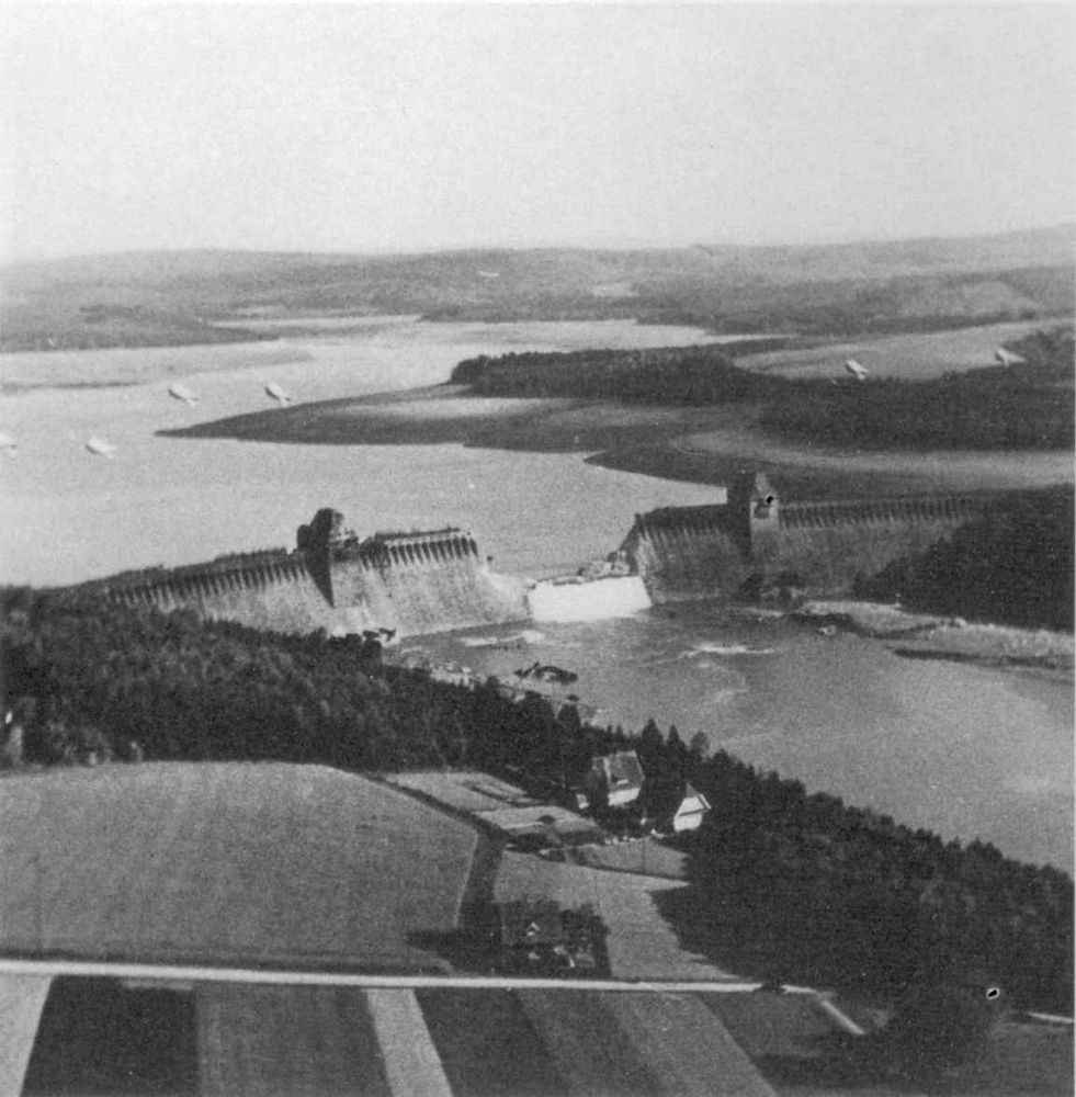  Photograph of the breached Möhne Dam taken by Flying Officer Jerry Fray of No. 542 Squadron from his Spitfire PR IX, six Barrage balloons are above the dam. Source: https://commons.wikimedia.org/wiki/File:Mohne_Dam_Breached.jpg