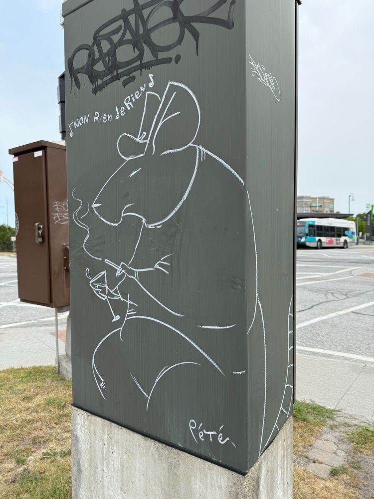 Grafitti of an anthropomorphic rat smoking a cigarette and holding a cocktail glass. Line art on a traffic signal control box. The lyrics “Non rien de rien” are written over its head and it is signed “Pété.”