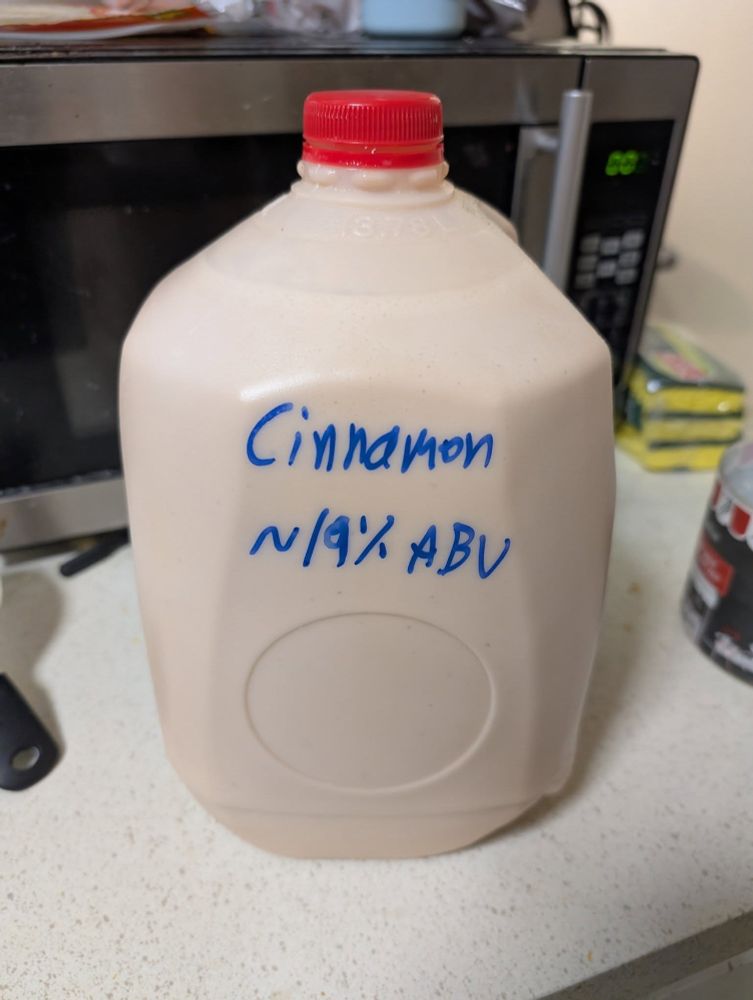 A gallon jug of eggnog, labeled "Cinnamon, ~19% ABV"