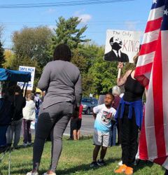 Little boy next to a poster of MLK saying “The only KING”