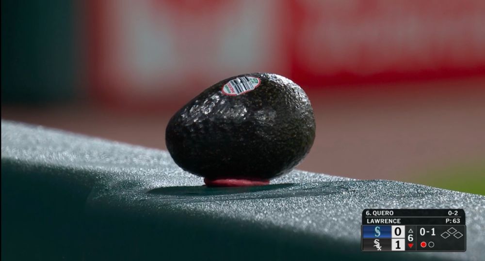 photo of an avocado stuck to a railing by a chewed piece of gum