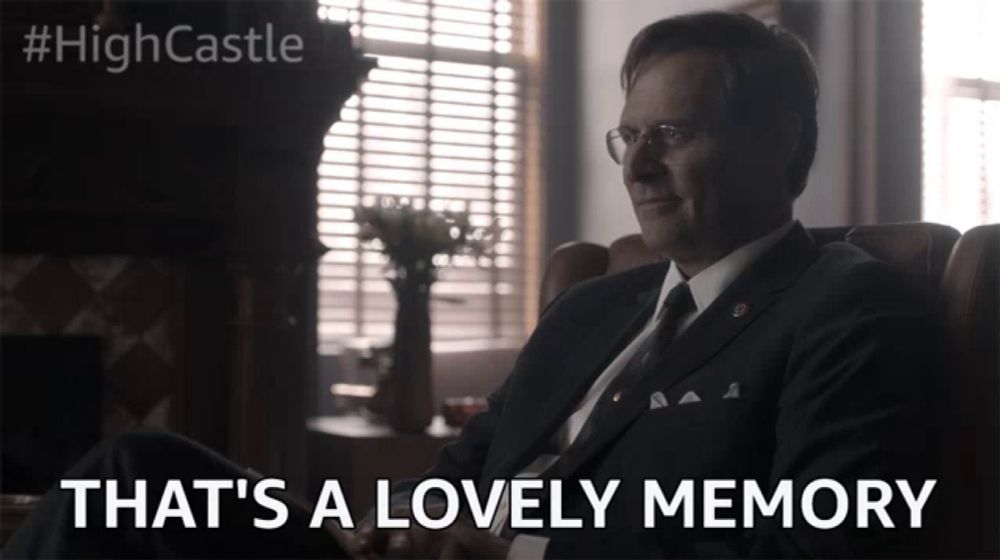 a man in a suit sits in a chair with the words that 's a lovely memory below him