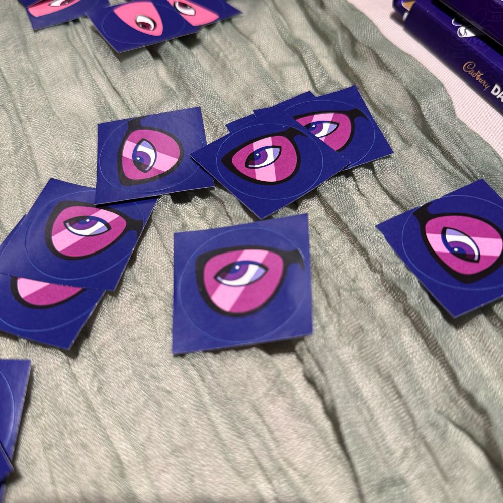 Purple stickers with an illustration of an eye behind sunglasses