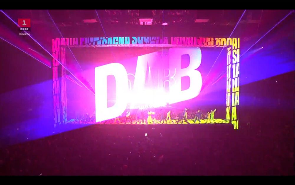 The stage of Eurovision 2025 showing a big "DAB" and some dancers doing a dab