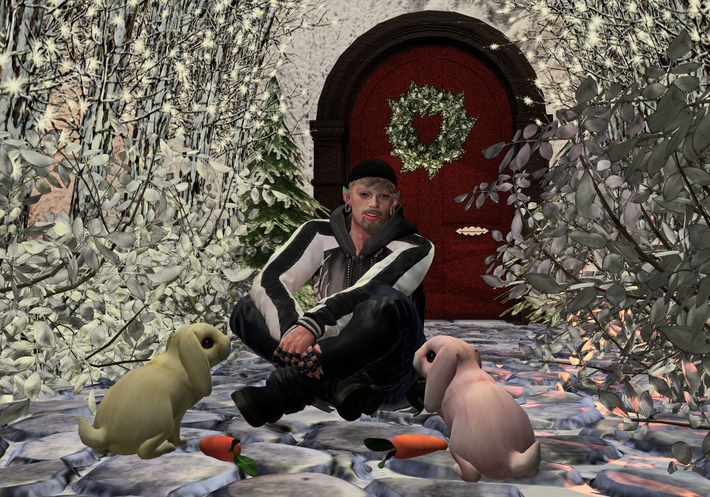 A male Second Life Avatar is sitting on the cobblestones in front of his home speaking to two floppy-eared rabbits.