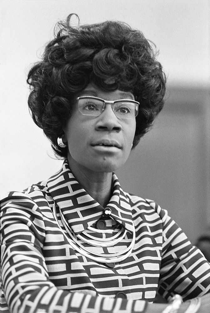 Shirley Chisholm wearing glasses and a striped outfit