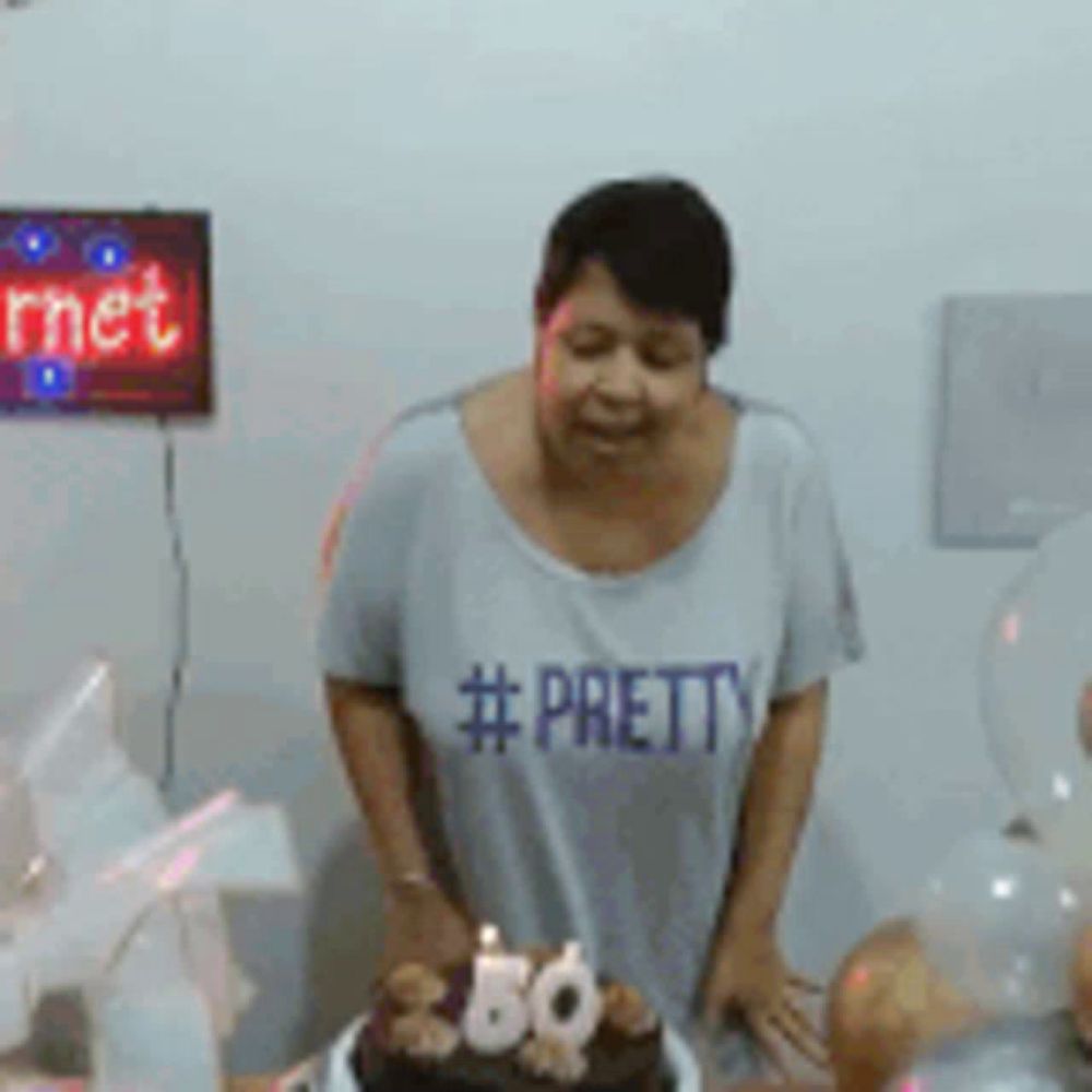 a woman wearing a #pretty shirt is cutting a cake