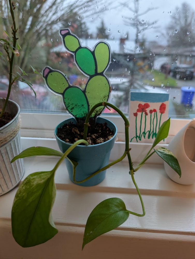 Another Queen Marble plant in a small tortoise pot with a plastic stained glass style accessory shaped like a cactus in the pot