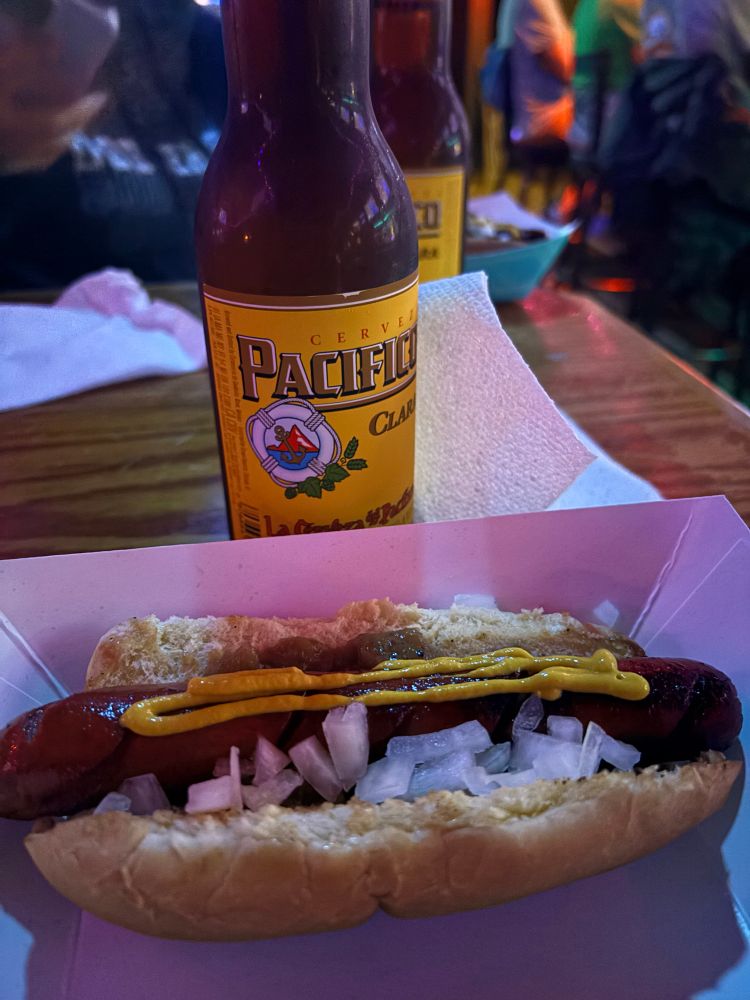 pacifico beer and a dodger dog (mustard, spicy relish, onions) on a bar table 