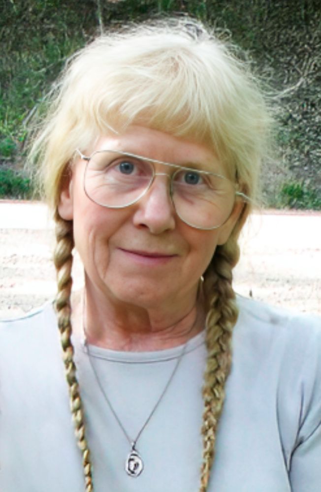 Smiling, red-haired woman with hair in braids.
