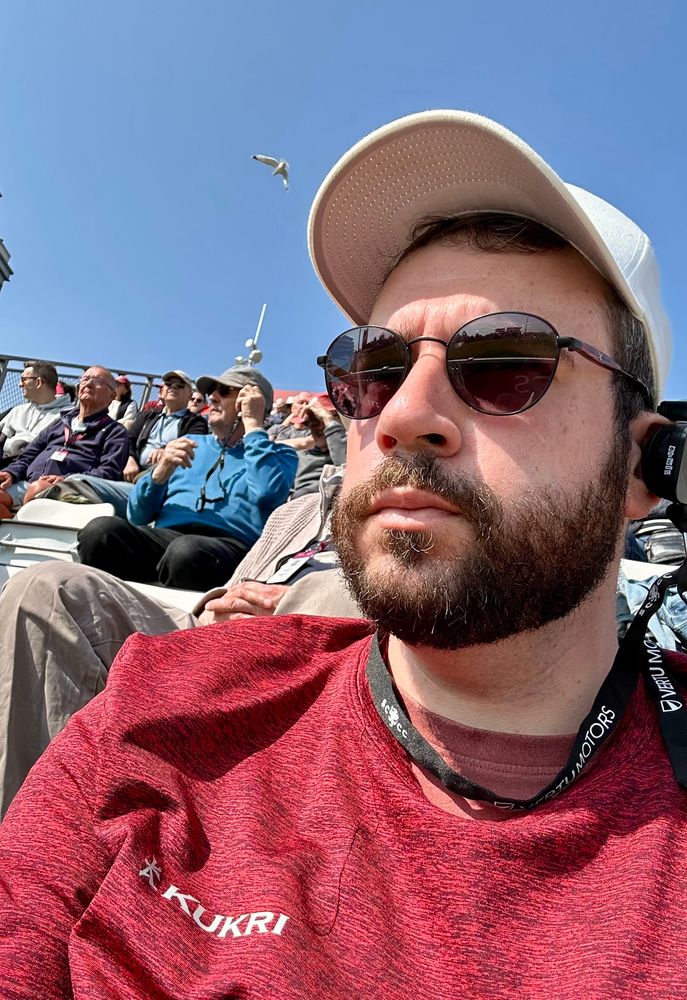 Selfie of a guy at a cricket stand.