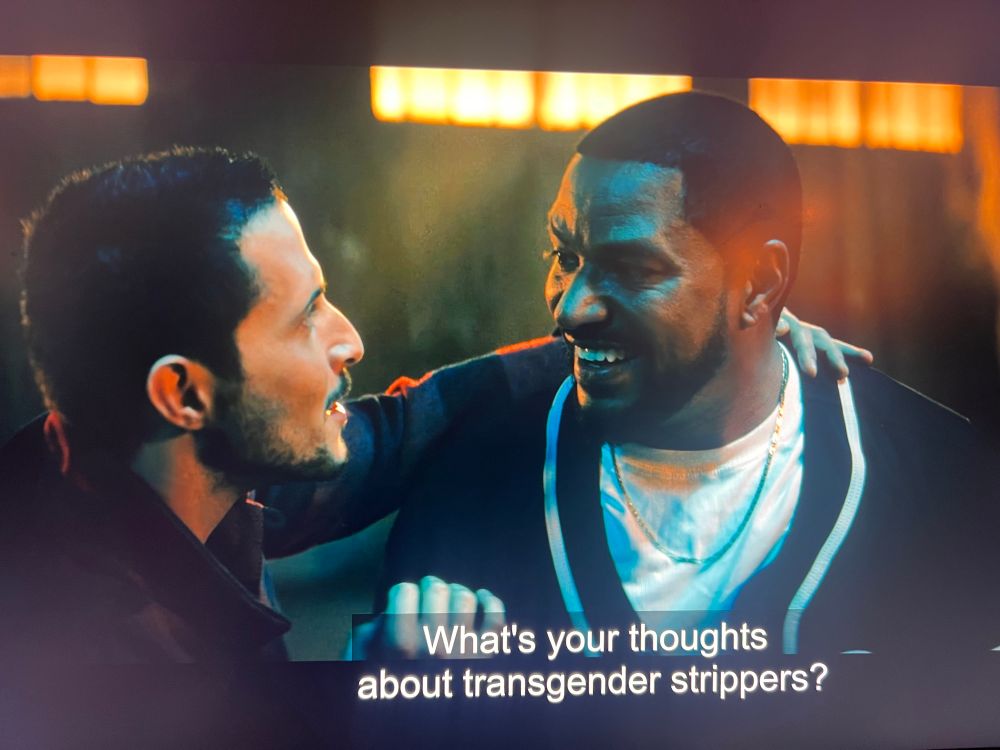 Picture of a man with his arm around another man excitedly asking “what’s your thoughts about transgender strippers” 