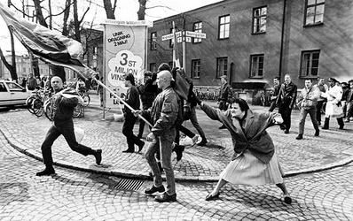 It shows a black and white photo of a rally, and a woman with a handbag is about to smack a follically challenged man on the back of his head. The man in questions is holding a nazi flag. This happened in 1985 in Sweden. 