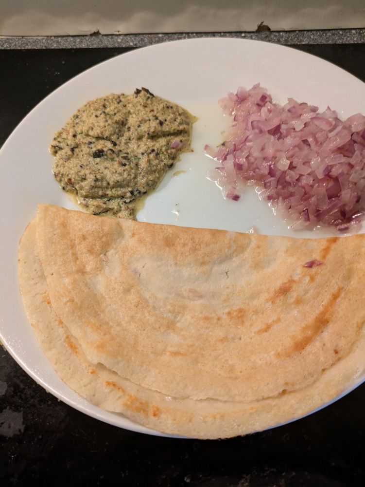 Dosa (south Indian) pan cake with some chutney and fried onions

