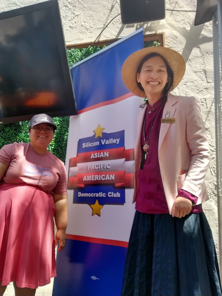 Emily and Alfred with a big banner with the Silicon Valley Asian Pacific American Democratic Club banner
