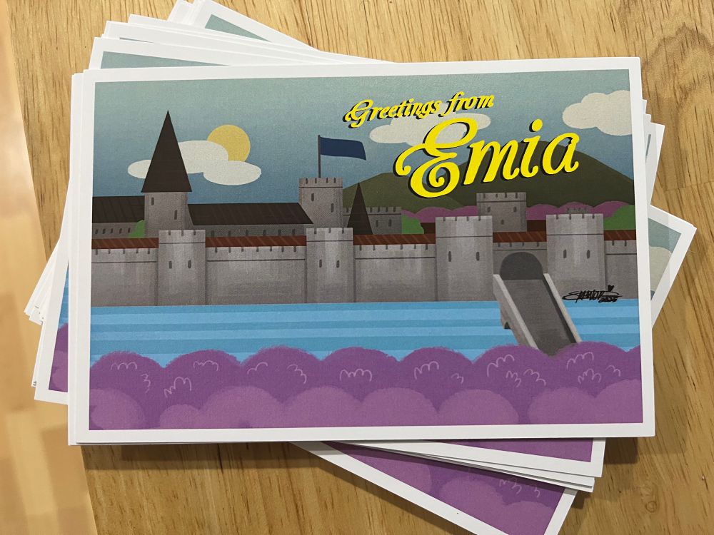 Pile of postcards that say Greetings from Emia. It features a stylized illustration of a castle surrounded by lavender.