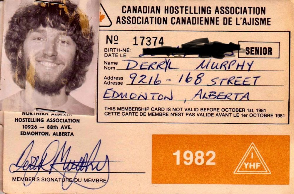 A 1982 Hostelling Association booklet cover with a B&W photo of me on the left. My hair is dark and existing, a curly mane kinda approaching my shoulders, and a full beard. My moustache is lighter and my signature still somewhat juvenile. I was not yet 19. 