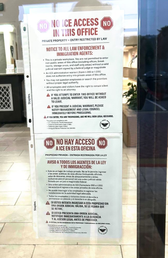 a sign posted on a glass door reads, "NO ICE ACCESS IN THIS OFFICE" Private Property -- Entry restricted by Law. NOTICE TO ALL LAW ENFORCEMENT AND IMMIGRATION AGENTS..." It goes on to detail that anyone entering the private workplace must have a valid judicial warrant. The sign is replicated in Spanish below. 