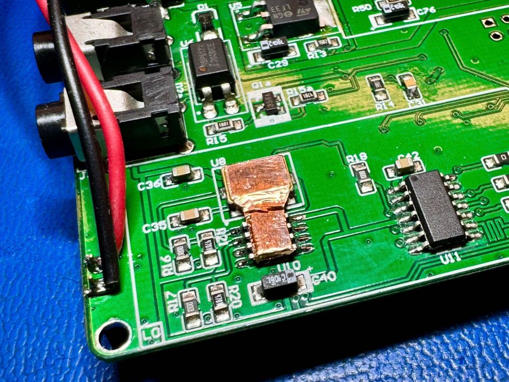 The mcHF RF board with an SO-8 Temperature sensor soldered on. There is a copper tape shape bridging across from the SO-8 To the square oscillator package.