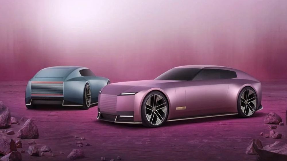 The new Jaguar Type 00. There are 2 cars in the image, one is pink and the other is blue/grey
