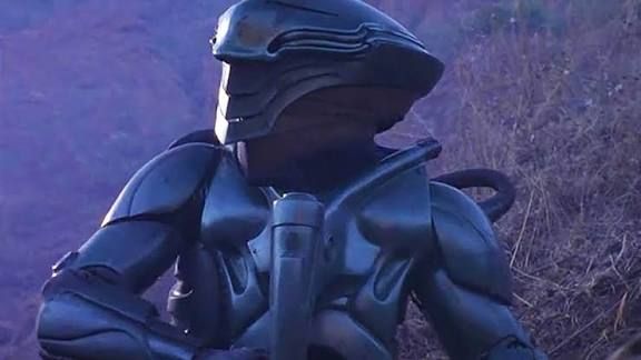 Alien suit from the TV show Space: Above and Beyond, showing a figure in dusk lighting, in a field. 