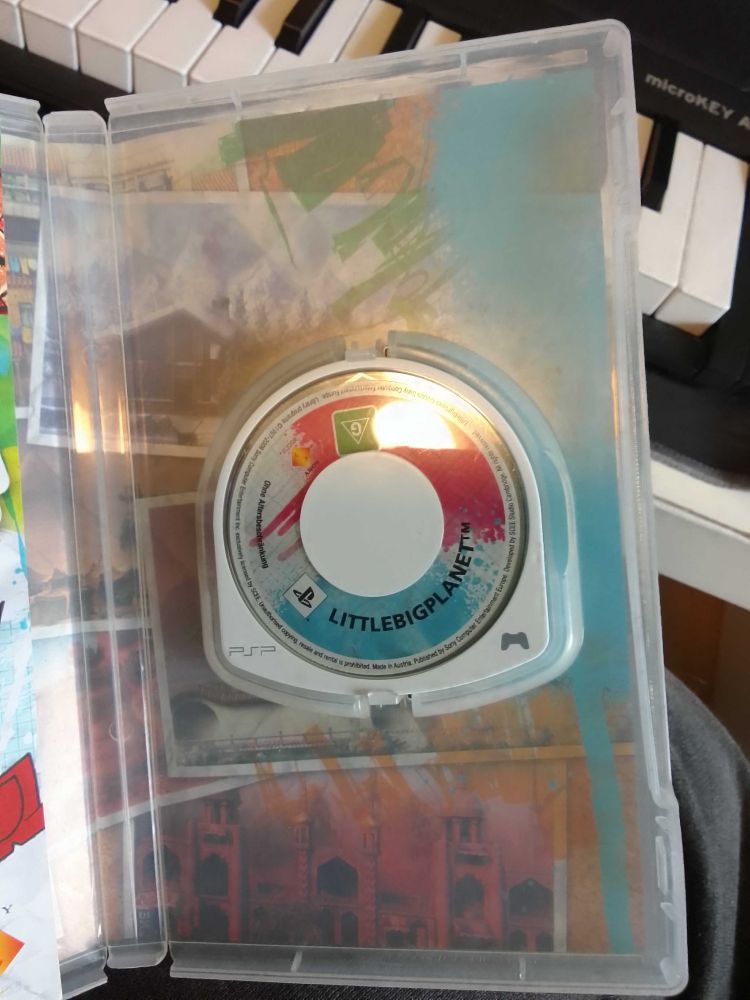 A photo of the UMD disc for Little Big Planet, inside the PSP game case.