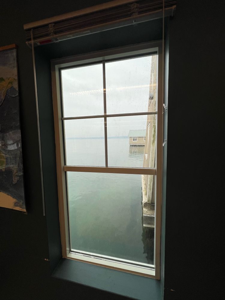 Classroom window which looks out onto Puget Sound. It’s a calm gray misty day.