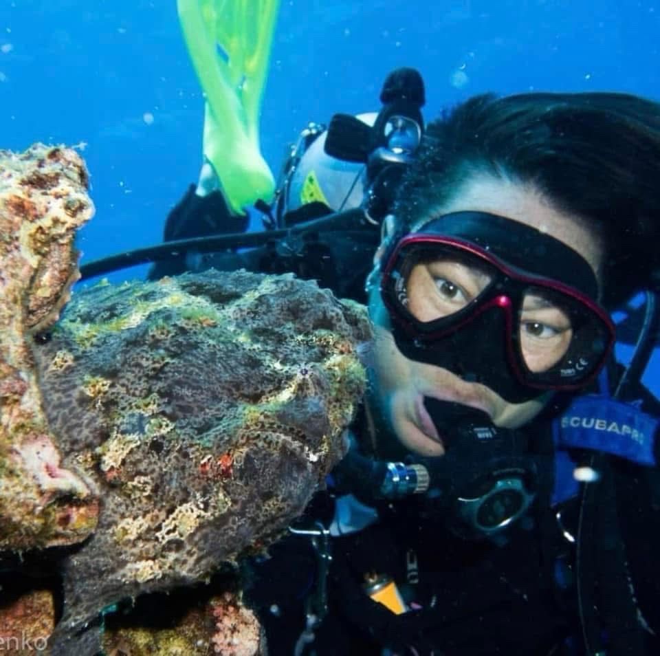 Dive instructor Kelleen Lum looks at a huge well-camouflaged frogfish.