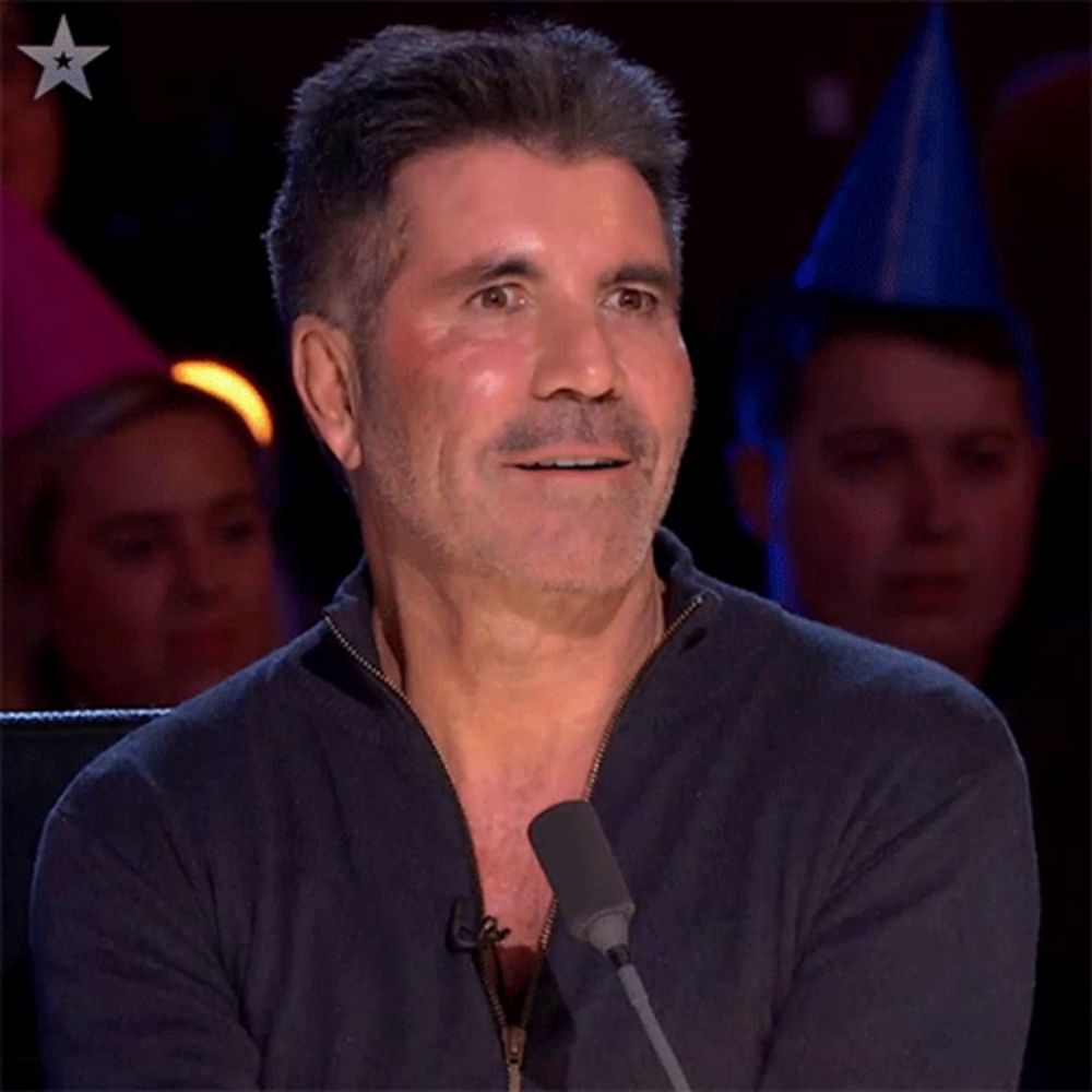 a man with a beard is sitting in front of a microphone with a star in the corner