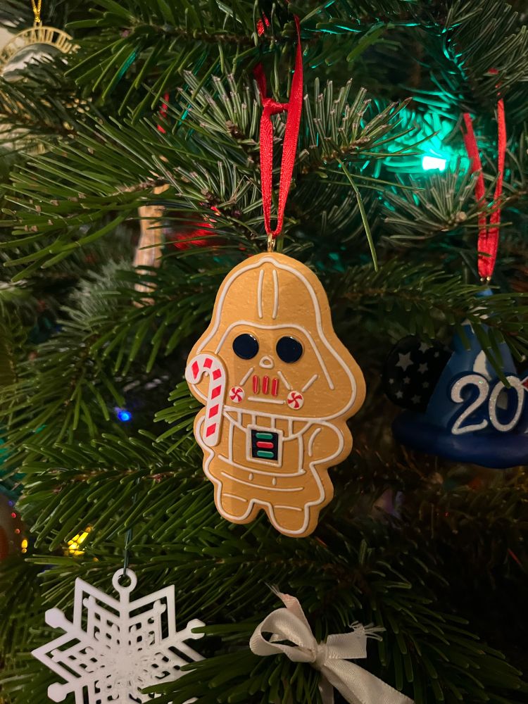 An ornament shaped like a gingerbread Darth Vader holding a candy cane
