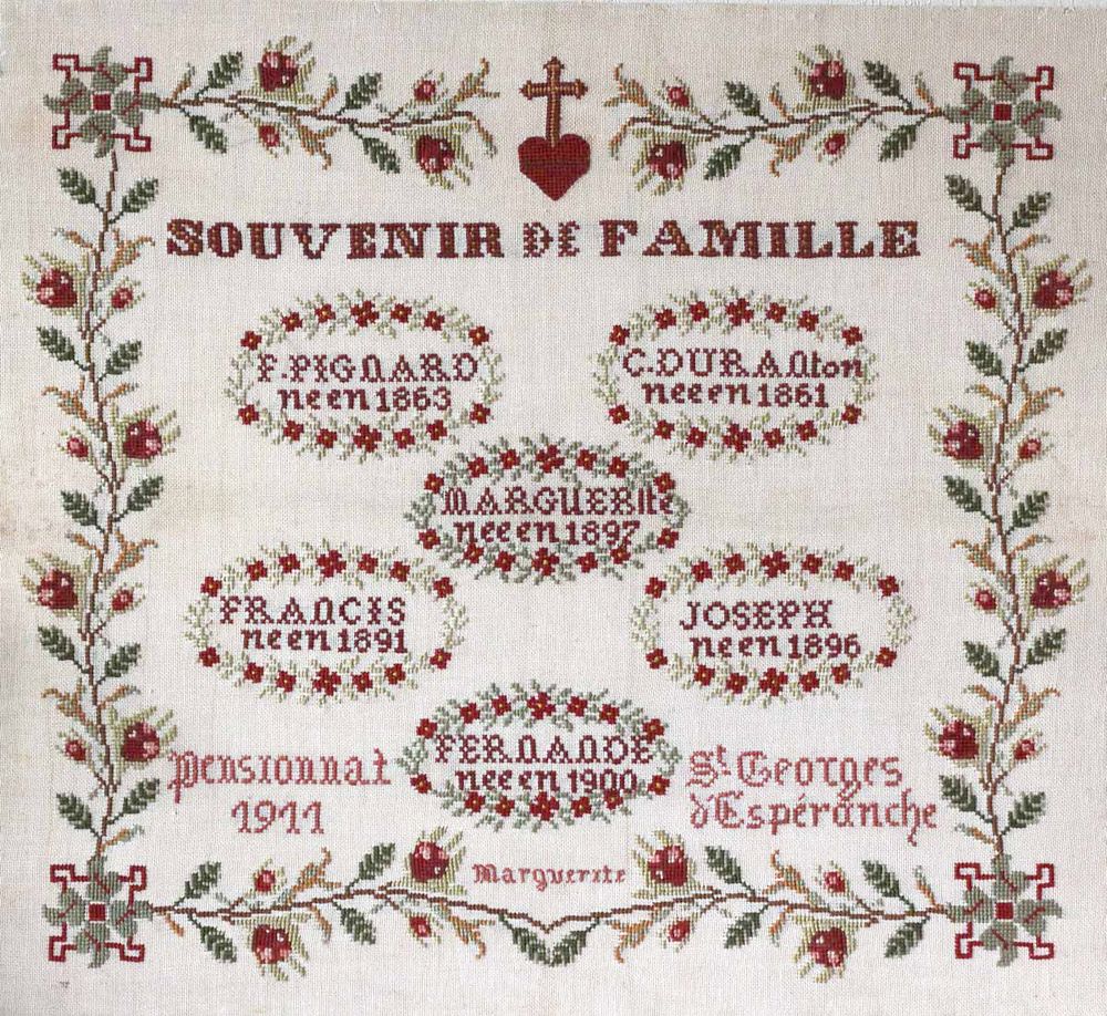 Marquoir intitulé "Souvenir de famille" et brodé par Marguerite Pignard en 1911, au pensionnat de St-Georges d'Espéranche. Elle y énumère les membres de sa famille avec leur date de naissance, le tout entouré d'une frise fleurie et surmonté d'un cœur sacré La broderie est dans des tons brique et verts.