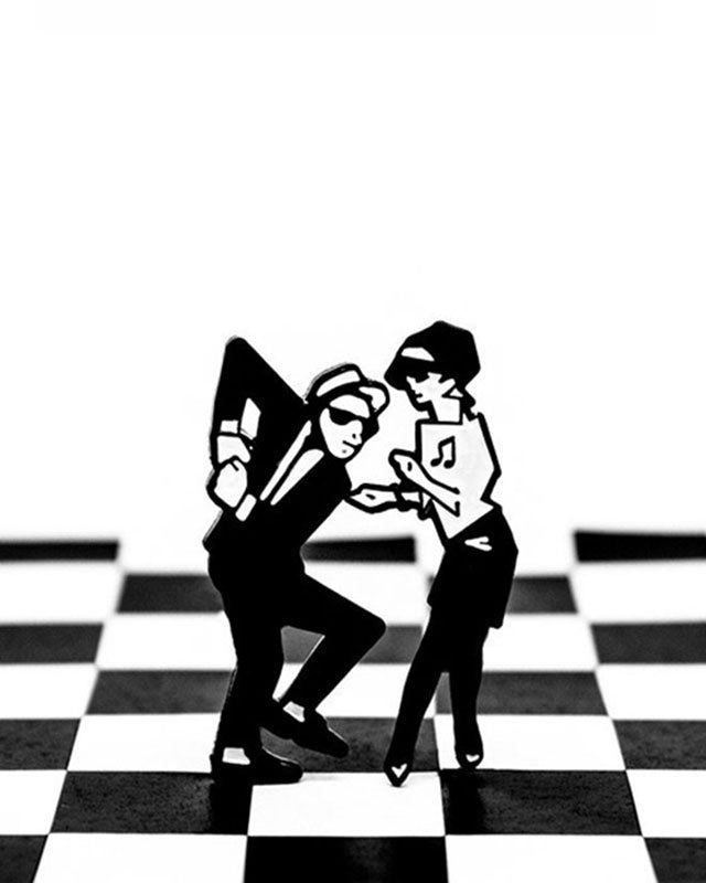 Two black and white figures skanking on a two tone background