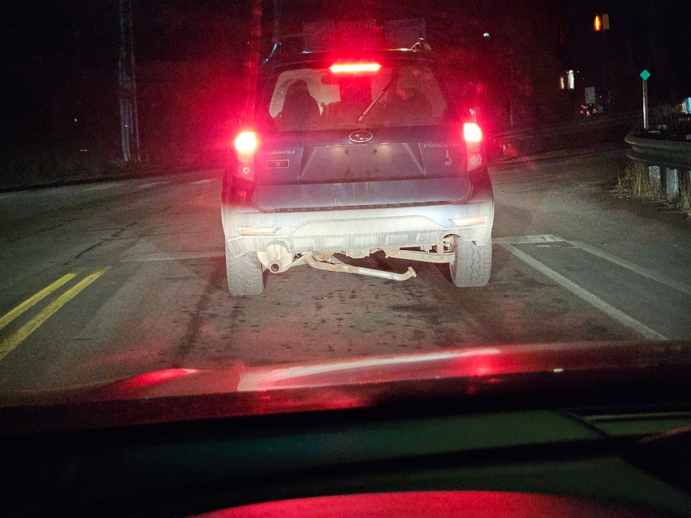 A Subaru Forester with no plates about to lose some important pieces in the road