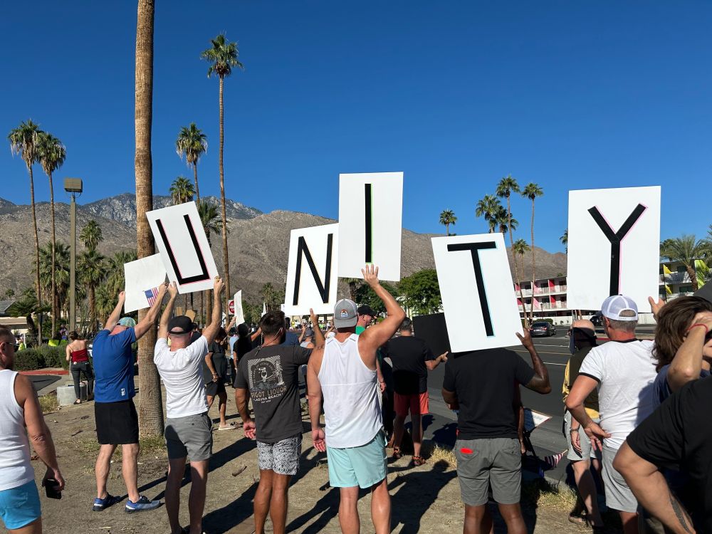 Protestors at No Kings Day on October 18 with a sign reading "Unity."