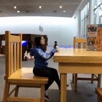 a woman sits at a table in front of a box that says table a chance