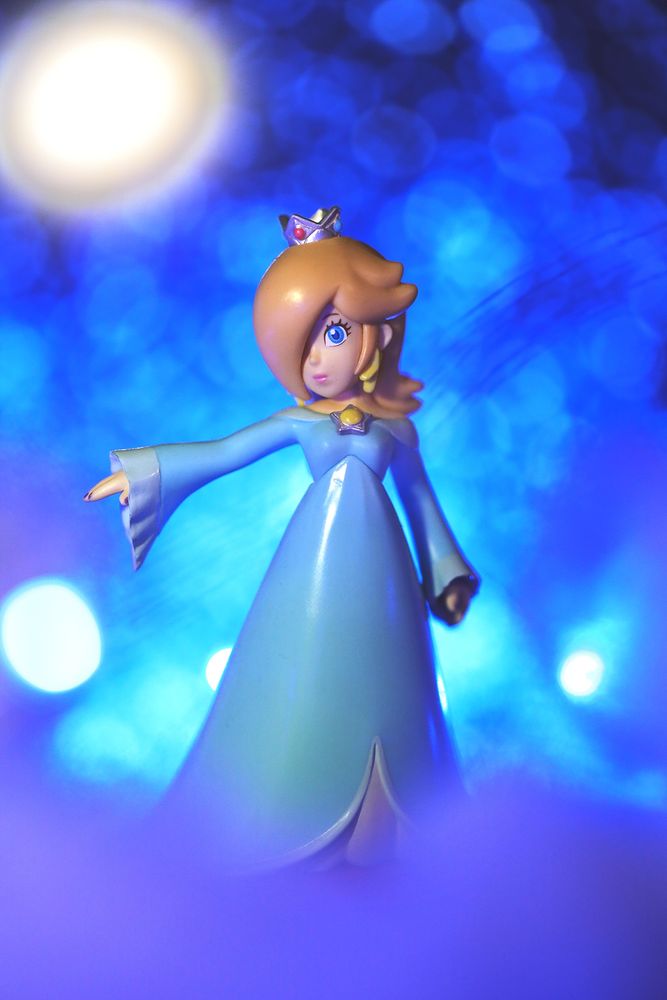 Rosalina amiibo (Super Mario series) from Nintendo standing against a blue ethereal background 
