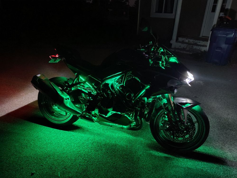 The right side of a motorcycle with green underglow