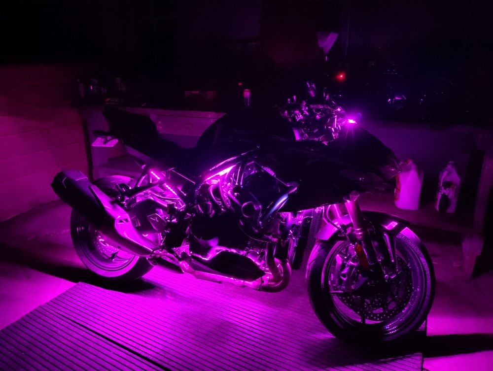 The right side of a motorcycle with purple underglow