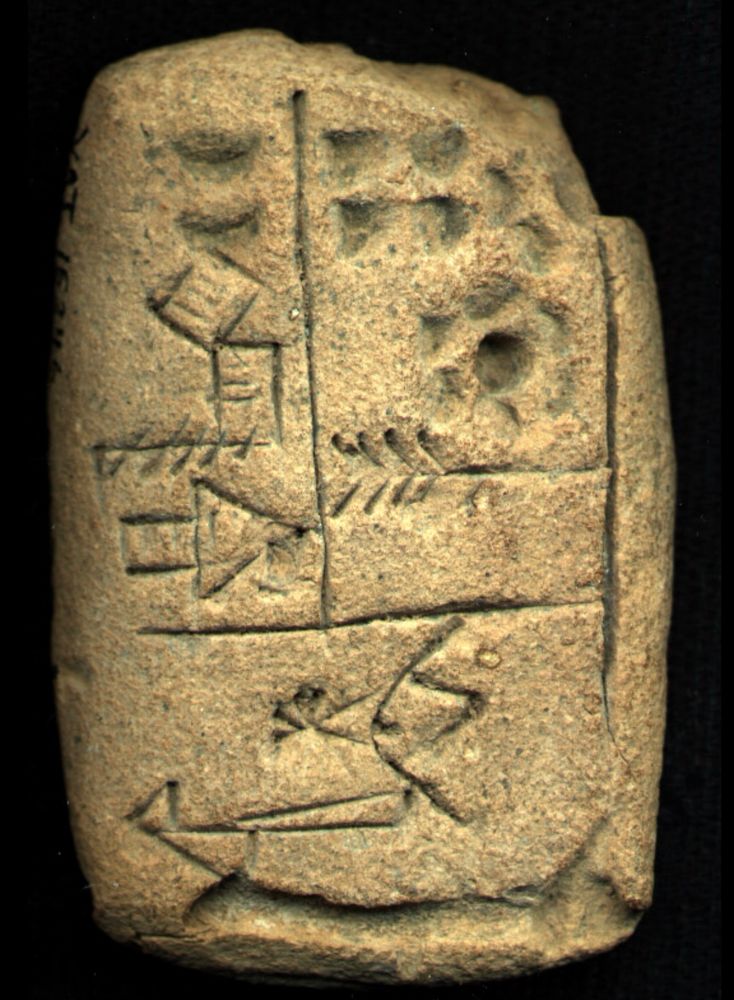 Photo of a clay tablet with traced drawings of objects separated into three boxes