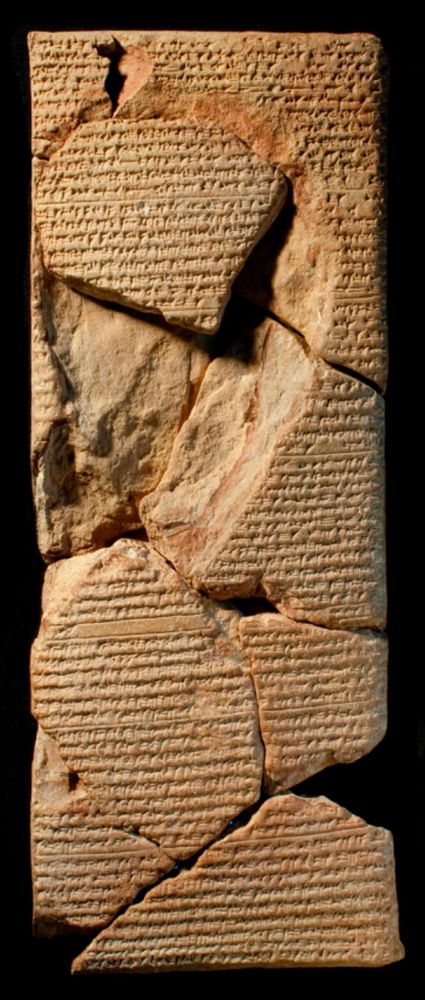 Photo of a broken cuneiform tablet with many lines of text. It is made up of several fragments put back together