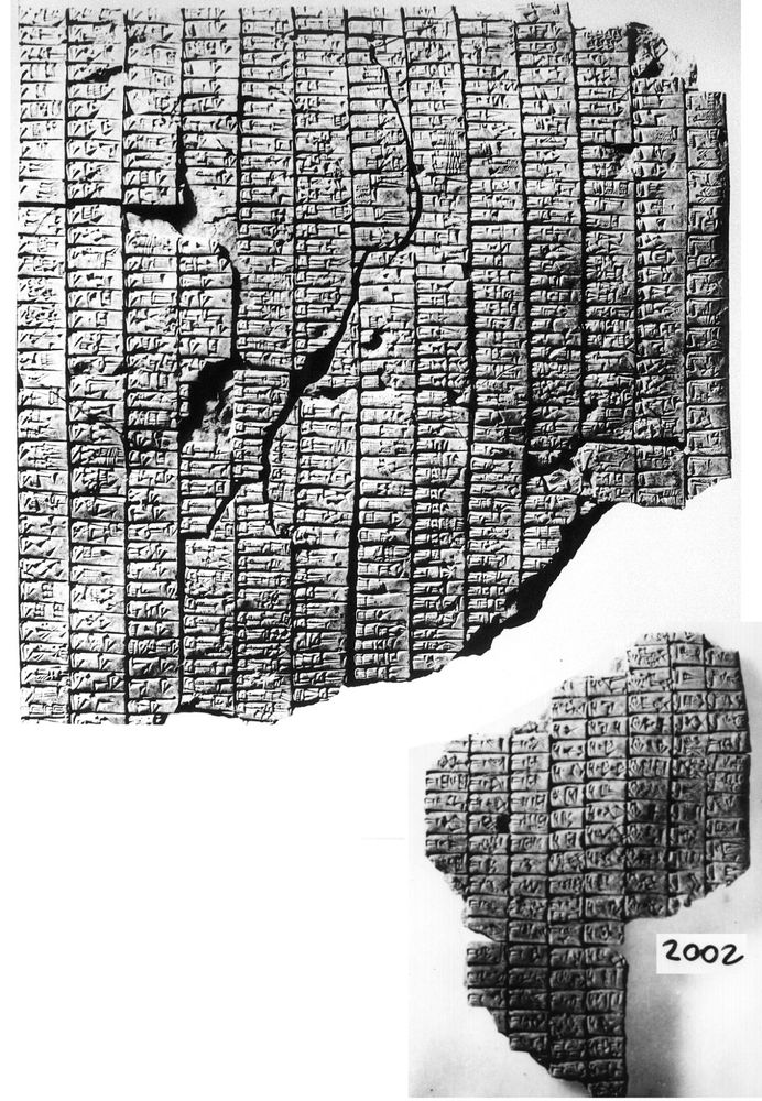 Black and white photo of a broken clay tablet, partially preserving 13 columns of text, and a second fragment with an irregular shape that preserves 8 columns of text
