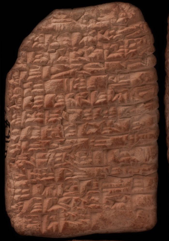 The front of a cuneiform tablet that is reddish brown in colour. The top left is missing, creating a smooth corner there. There are a few cracks throughout but it’s otherwise legible