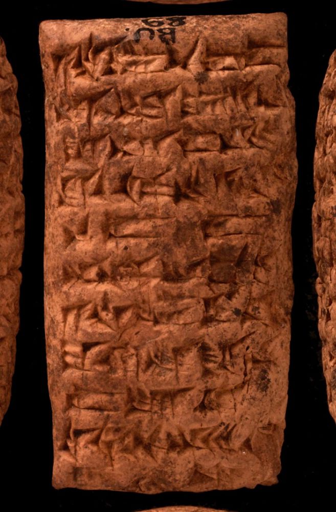 Photo of a portrait shaped clay tablet with well-preserved cuneiform signs. 