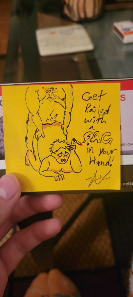 A pen and ink drawing of two fat men having sex doggy style. The bottom is biting his lip and has a cigarette in his hand. The caption read "get railed with a fag in your hand!" The word "fag" is made of the smoke from the cigarette.