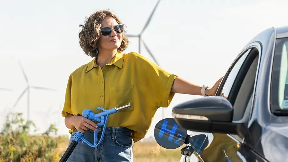 Een vrouw die waterstof tankt voor haar auto.