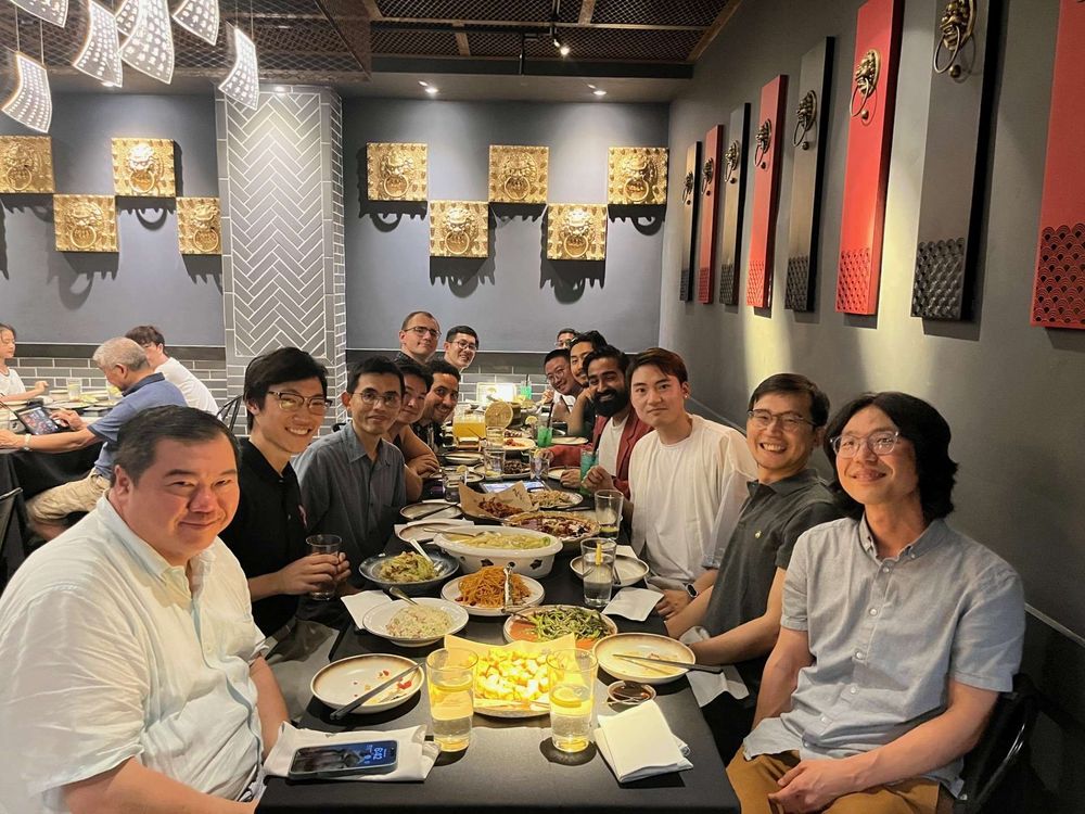 Dr. Andy Szeto, Lawrence Yu, Zuobin Tang, Ihn Lee, and others seated at a long restaurant table with many dishes.